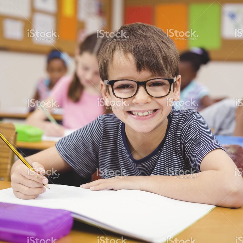 stock-photo-72396111-little-boy-working-at-his-desk-in-class
